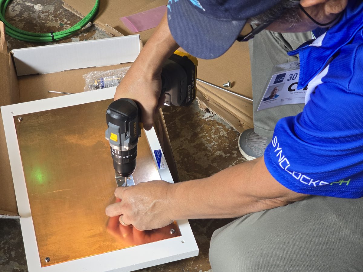 CSI technician in SynClocks PH uniform installing a synchronized clock system on site