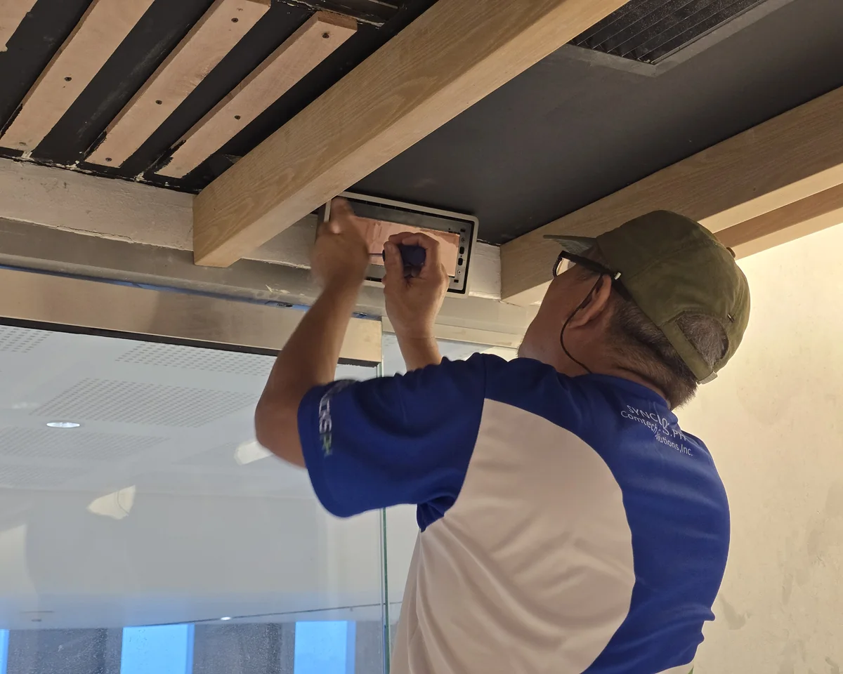 CSI technician in SynClocks PH uniform installing a synchronized clock system on site