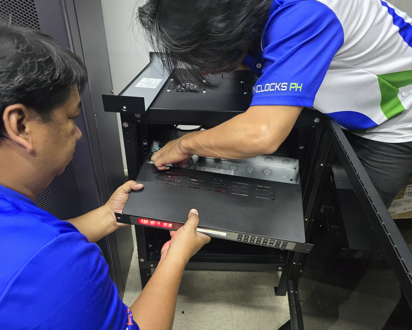 CSI technical specialists in uniform delivering a synchronized clock installation